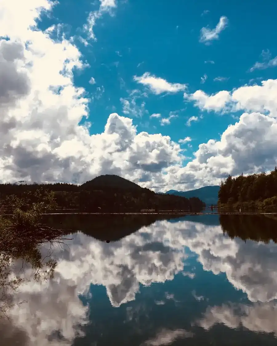 Cowichan Lake reflecting clouds and forested hills